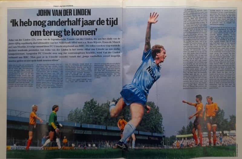Voetballer springt hoog tijdens een wedstrijd, omringd door spelers in gele en oranje shirts.