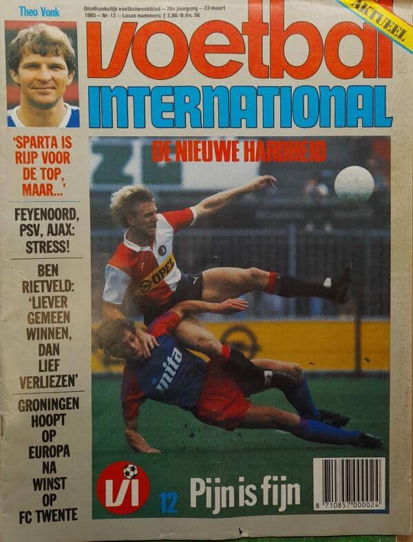 Voetbal International cover met een speler die een tackle uitvoert tijdens een wedstrijd.