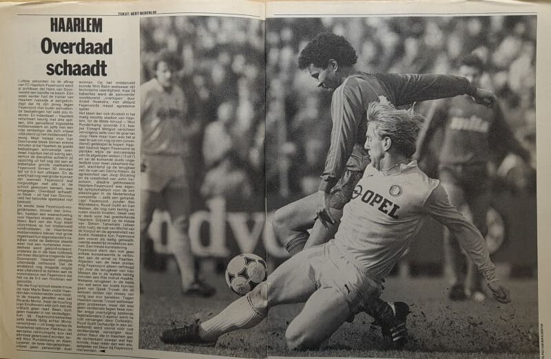 Voetbalwedstrijd met twee spelers in actie, zwart-wit foto.