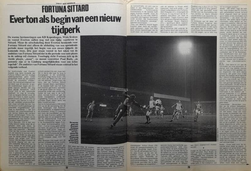Zwart-wit foto van een voetbalwedstrijd met spelers in actie onder stadionverlichting.