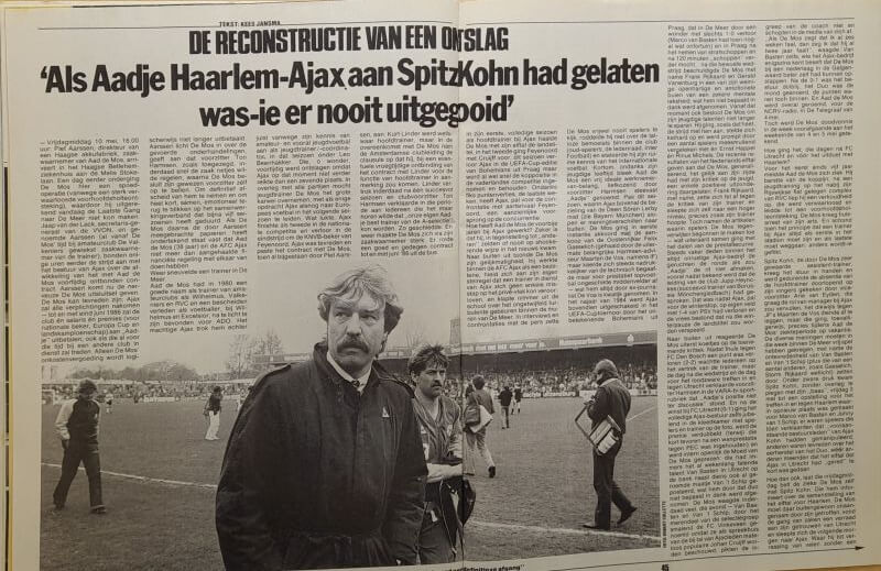 Man staat voor een grote krant met artikel over herbouw na explosie.