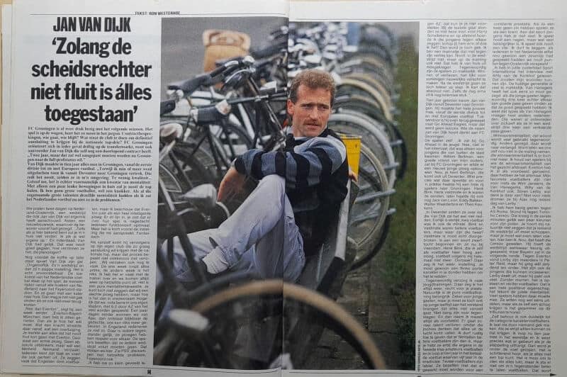 Man zit tussen fietsen in een fietsenstalling, omringd door rijwielen.