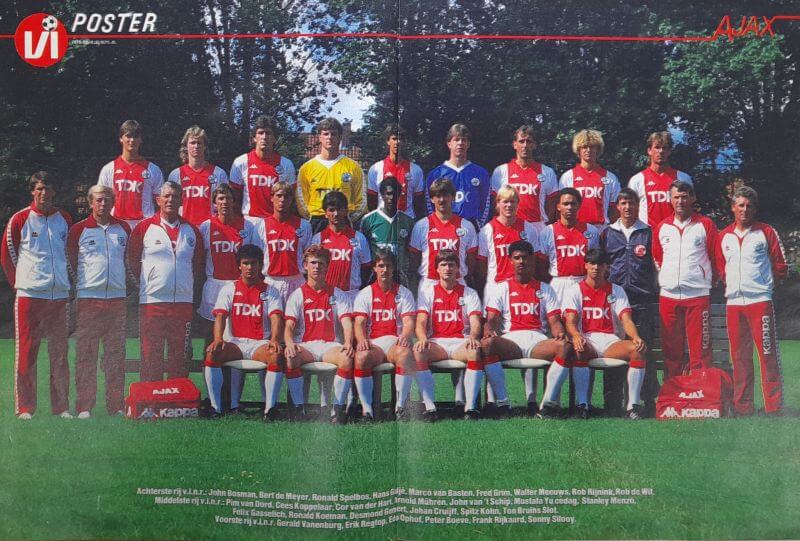 Voetbalteam in teamoutfits poseert op het veld voor een groepsfoto.