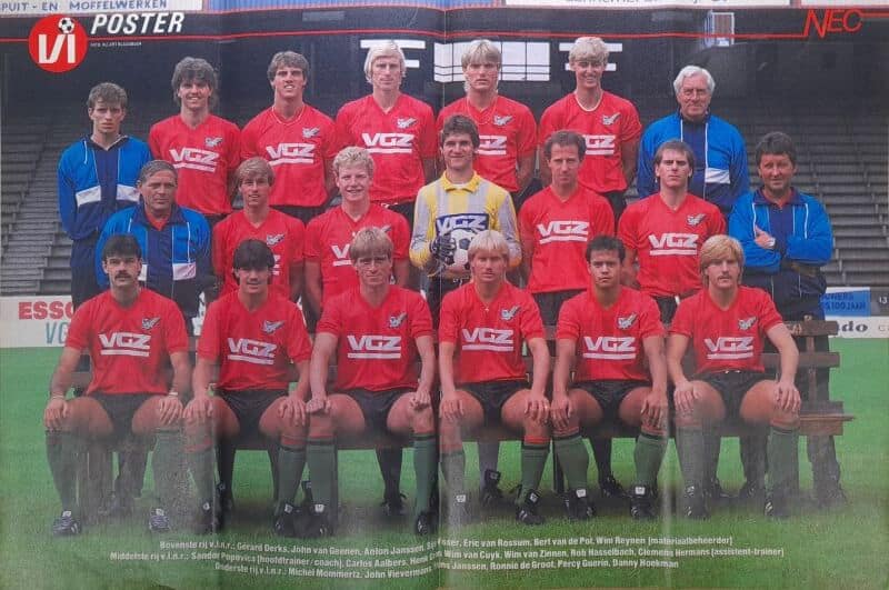 Voetbalteam in stadion met coach en spelers in rood en blauw.