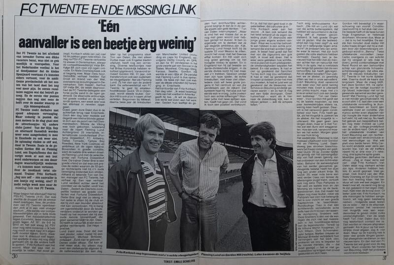 Drie mannen op een voetbalstadion, zwart-wit foto uit 1985.