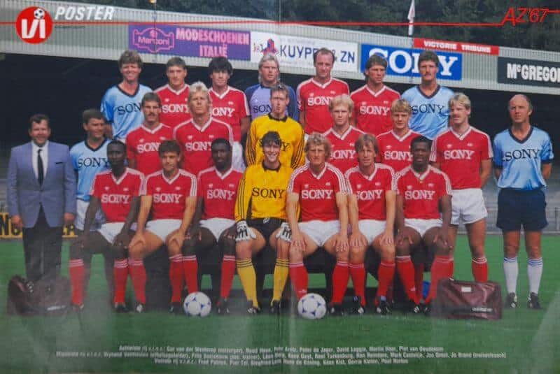 Voetbalteam uit 1985 met spelers in rood en blauw uniform.