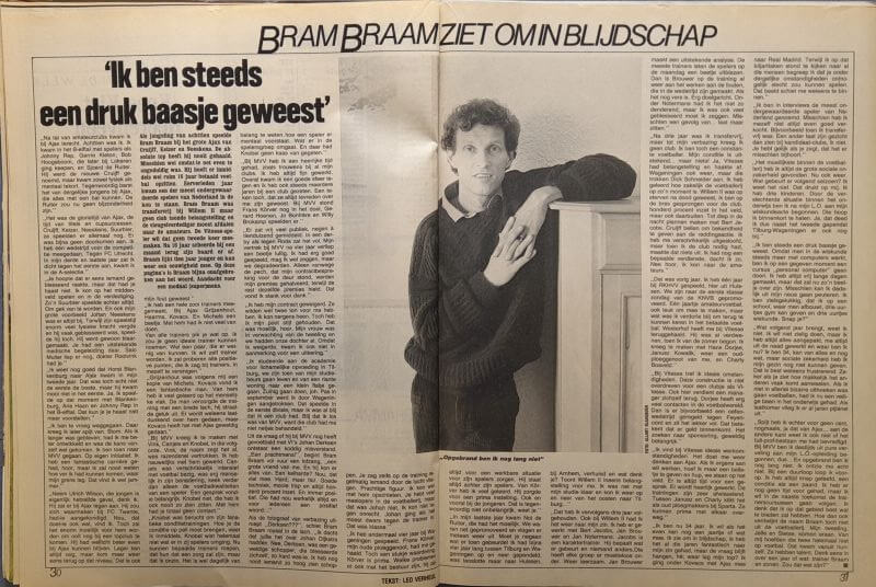 Jonge man met krant in zwart-wit foto, staand naast kast.