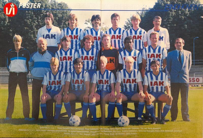 Voetbalteam in blauwe en witte shirts, poseert op het veld.
