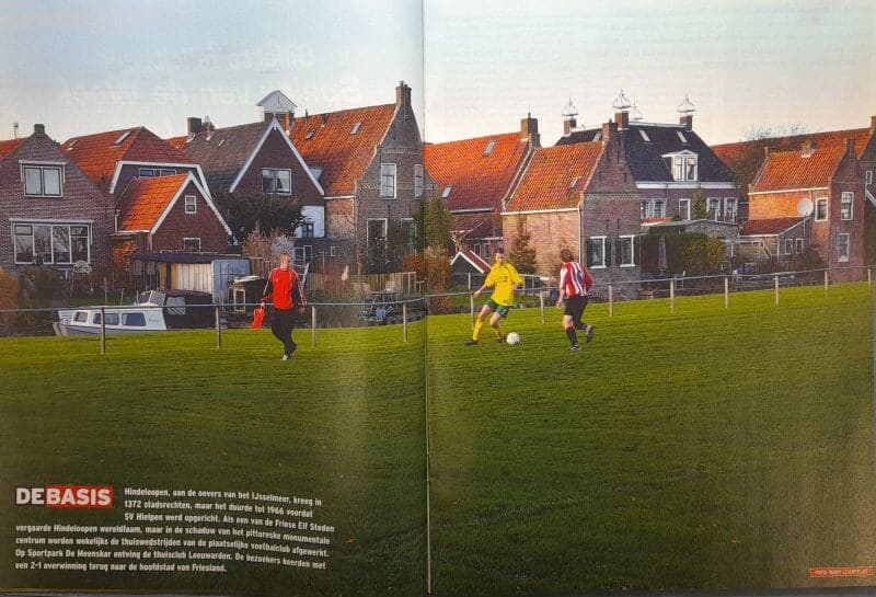 Drie spelers in actie op een amateurvoetbalveld in Friesland.