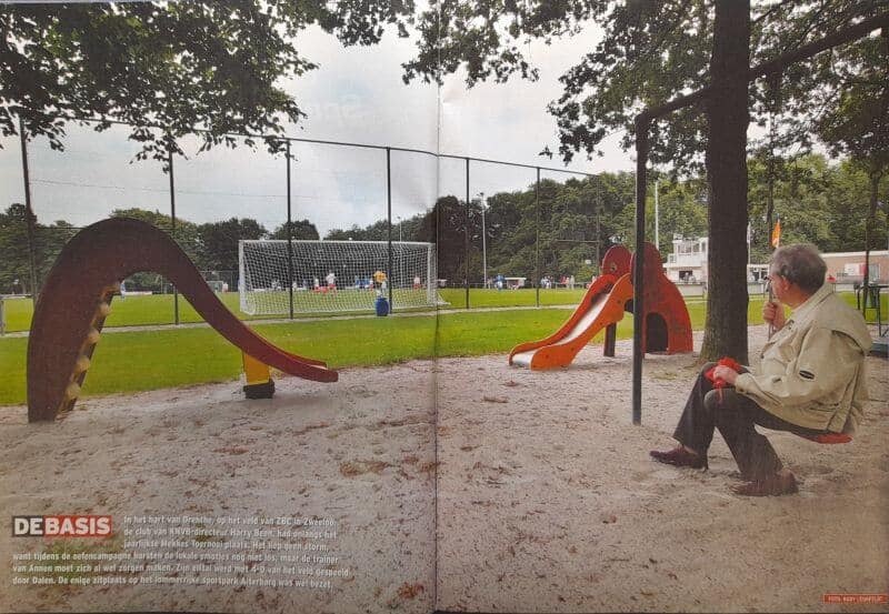 Kinderspeelplaats op sportveld in Drenthe met schommels en glijbaan.