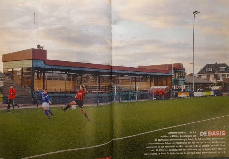 Amateurvoetbalwedstrijd op een veld in Friesland met spelers in rood en blauw.