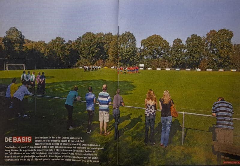 Mensen kijken naar een amateurvoetbalwedstrijd op een grasveld in Drenthe.