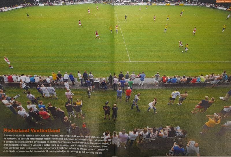 Publiek kijkt naar een voetbalwedstrijd op een amateurveld in Friesland.